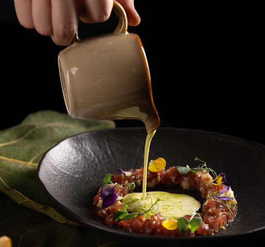 Pouring ajoblanco on tuna tartar