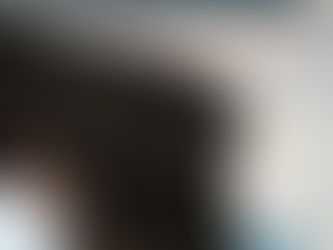 Jennie Brand sitting on volcano rocks in Nusa Penida waiting for sunrise overlooking the ocean.