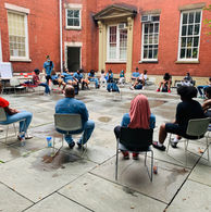Group seated in a circle for a meeting in a courtyard