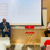 Speakers at a presentation with a checklist slide.