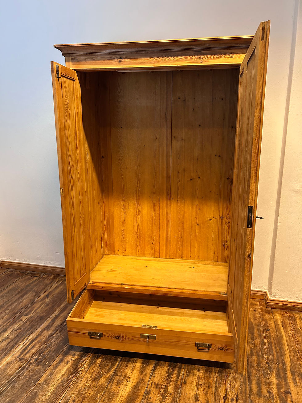 zweitüriger Kleiderschrank aus Weichholz auf Holzboden vor weisser Wand
