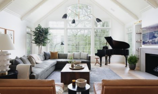 living room with a large grey sectional, black grand piano, and two matching leather chairs