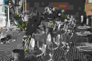 A table with a checkered cloth and tall floral arrangements.