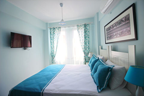 Nilada Standart Oda - Bozcaada butik otel konaklaması için modern ve konforlu oda tasarımı. Nilada odalarında klima, TV ve minibar gibi konfor detayları.