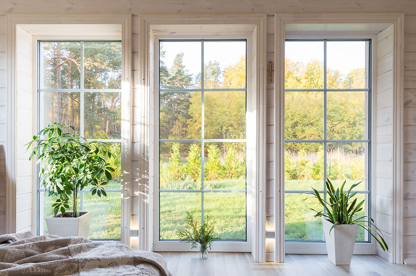 helles-interieur-des-zimmers-im-holzhaus-mit-einem-grossen-fenster-mit-blick-auf-den-herbs