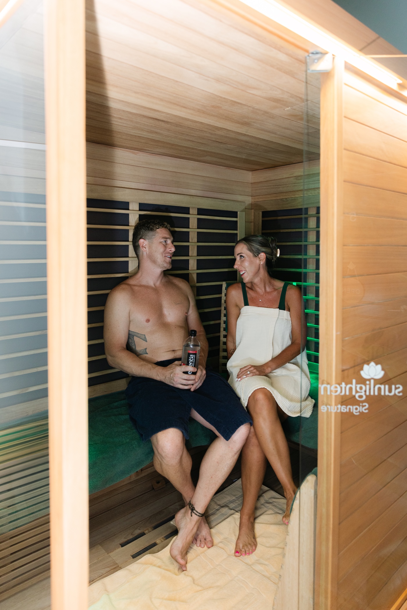 Two guests seated together in the sauna half of the contrast suite