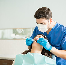dentista-masculino-examinando-una-mujer-joven-con-tallador-dental-en-la-clinica-medica.jpg