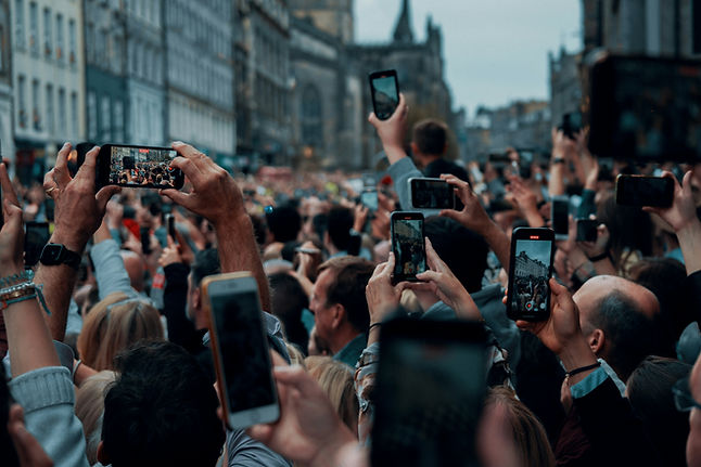 a large group of people outside all holding their mobile phones up