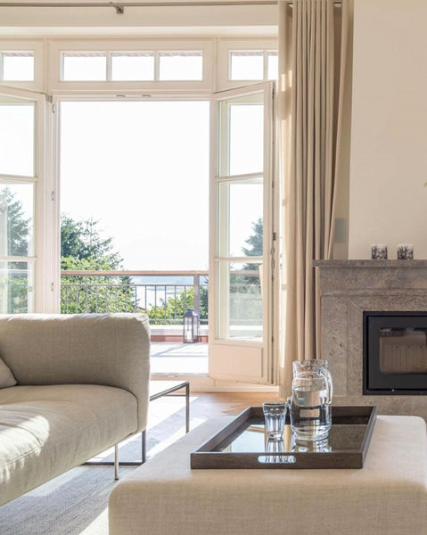 view from living room with fireplace and light sofa and pouf