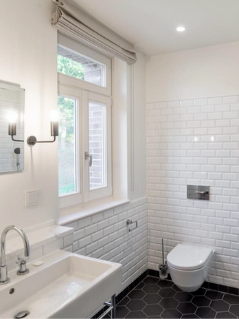 white metro tiled bathroom with toilet, window and sink