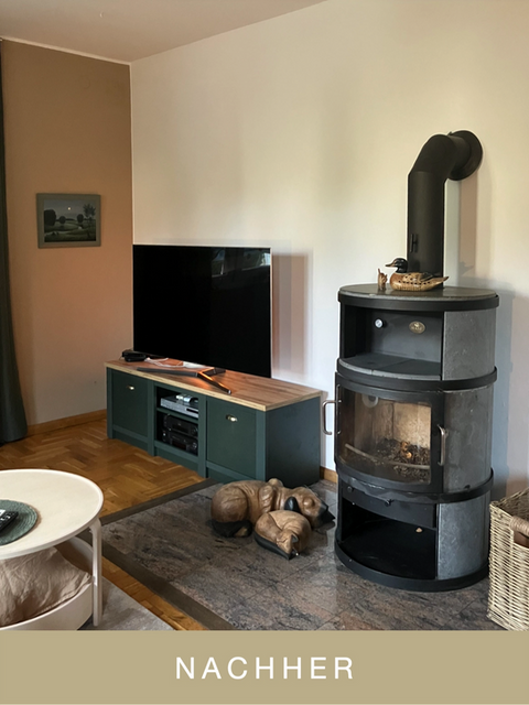 corner of a room with TV on a lowboard next to a wooden stove with walls in two tones of beige