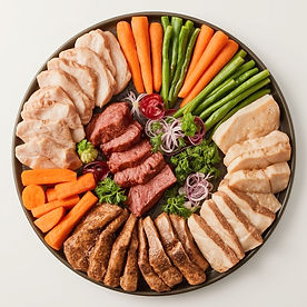 A vet-approved nutritional platter for a pet recipe, with sliced meats, fresh carrots, and green beans