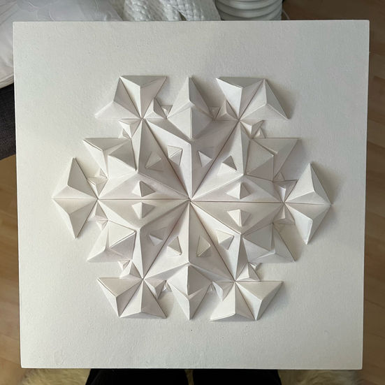a snowflake made of white triangles on a white surface