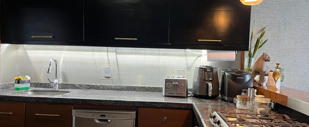 Cocina con barra de granito brasileño, parrilla empotrable marca Teka de 6 quemadores, campana Whirpool y lavavajillas Maytag