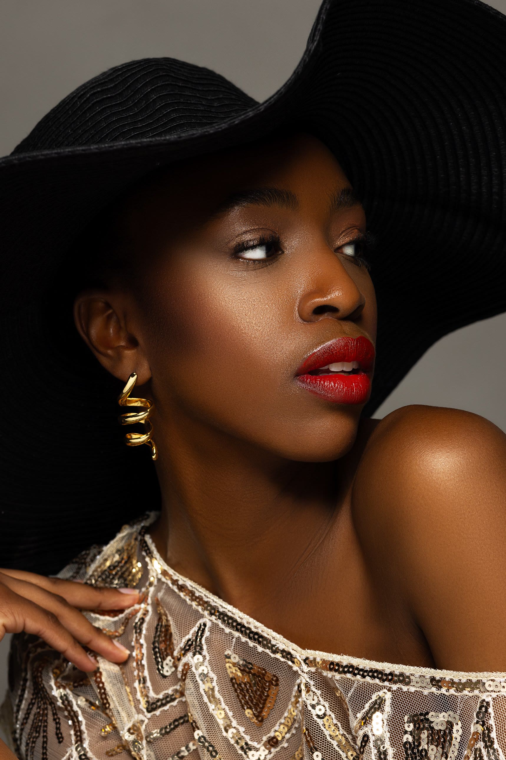 Shooting-Ergebnis: Editorial-Look mit rotem Lippenstift, schwarzem Hut und goldenem Ohrring
