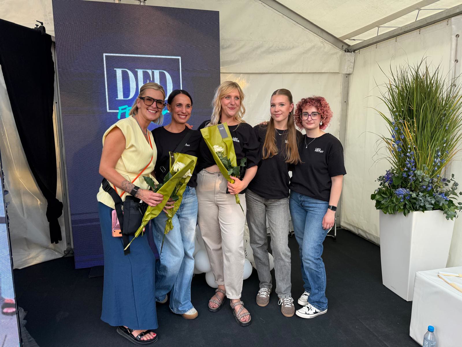 Leo Artist Team mit Blumen nach einer Modenschau