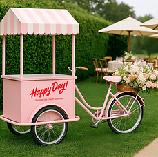 "A pastel pink ice cream tricycle cart with a striped canopy and the words 'Happy Day!' on the side, decorated with a basket