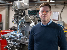 Man in front of a machine with safety glasses on
