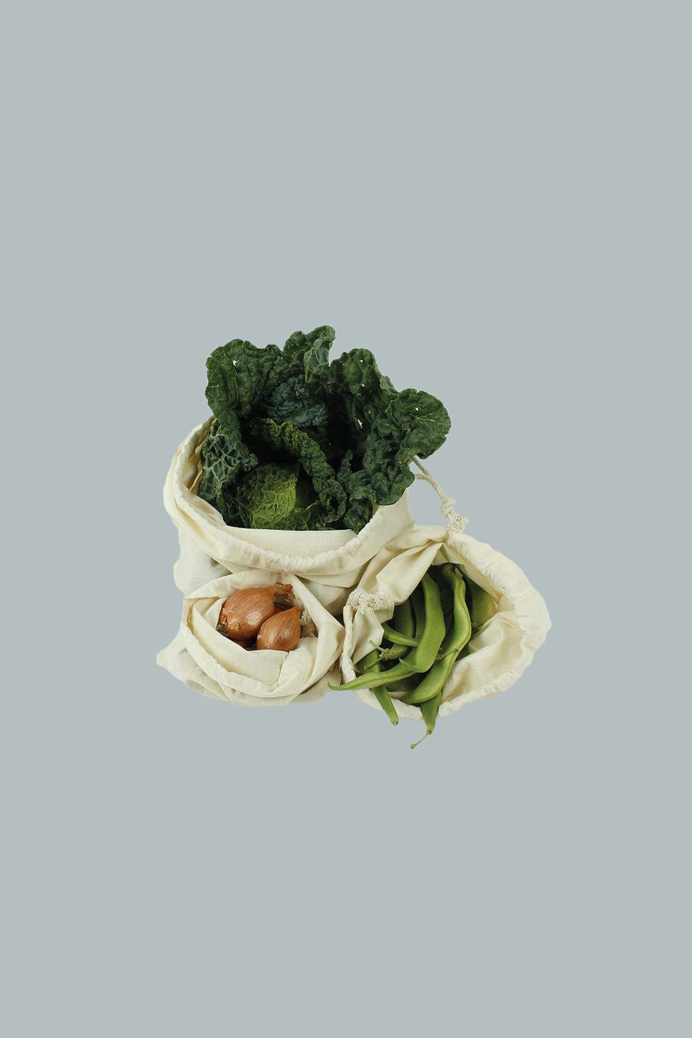 Three produce bags with vegetables sticking out of them