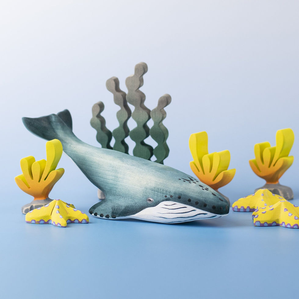 Bumbu Toys Wooden Blue Whale in a small world ocean scene with coral, seaweed, and marine plants.