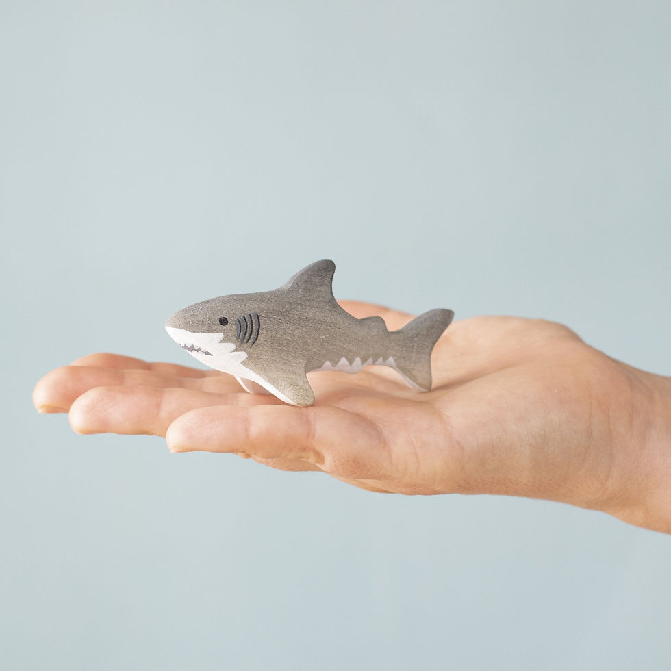 Thumbnail: Bumbu Toys Wooden Baby Shark figure held in an adult hand to show size and detail.