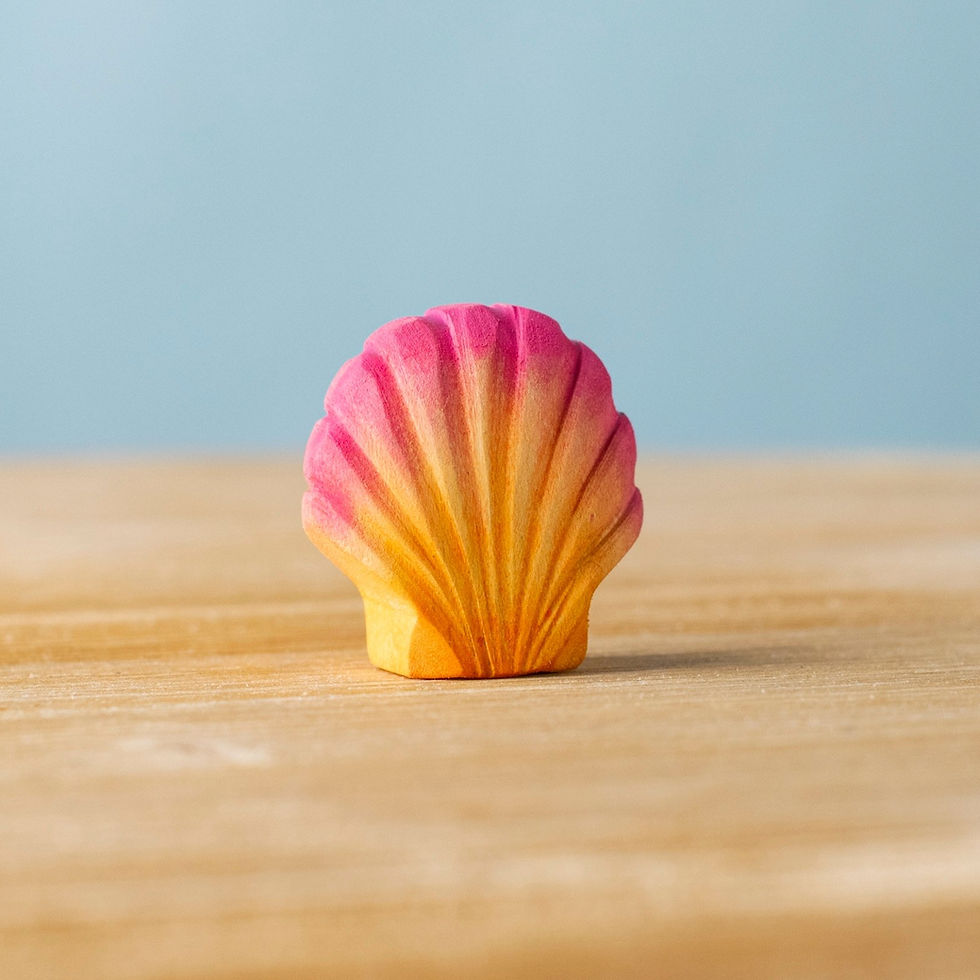 Bumbu Toys Wooden Pink Seashell standing upright on a wooden surface, showcasing its hand painted detail