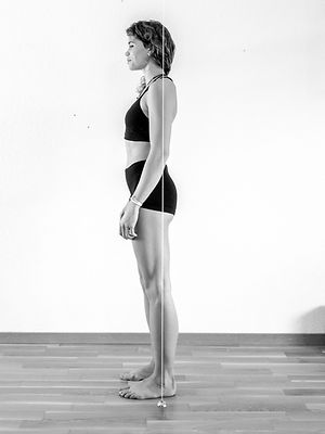 Évaluation de la posture à l’aide d’une ligne de plomb, un outil essentiel pour observer les asymétries corporelles, détecter les écarts dans l’alignement des articulations et poser les bases d’un plan de correction personnalisé.