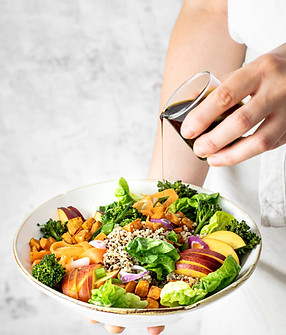 woman-pouring-pumpkin-seed-oil-sweet-potato-buddha-bowl.jpg