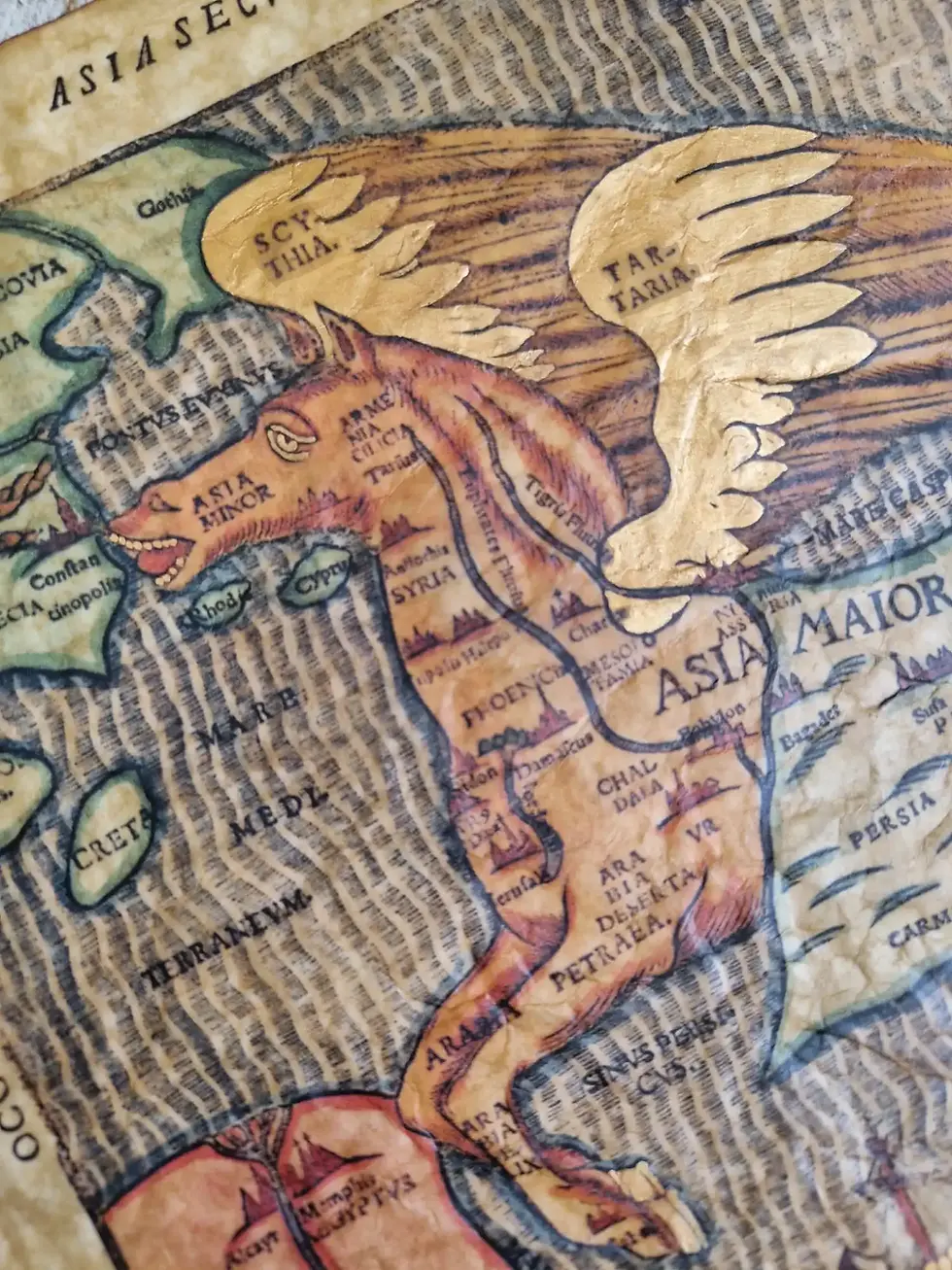 A close-up detail of the gold-painted wings on the Asia in Forma Pegasi map. The image shows the texture of the beeswax finish and the names Scythia and Tartaria.