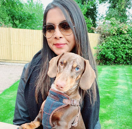 Woman and brown Dachshund dog with blue eye at picnic table