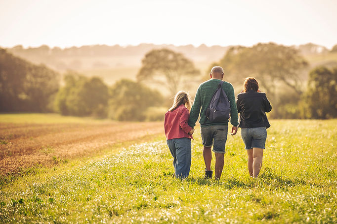 Parents and child walking in a sunny field