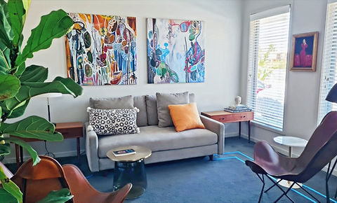 Lisa Moore's counselling practice room on the Tweed Coast with sofa, cushions, natural light and colourful artworks