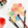 create a watercolor pallette and brushes laying on paper.jpg
