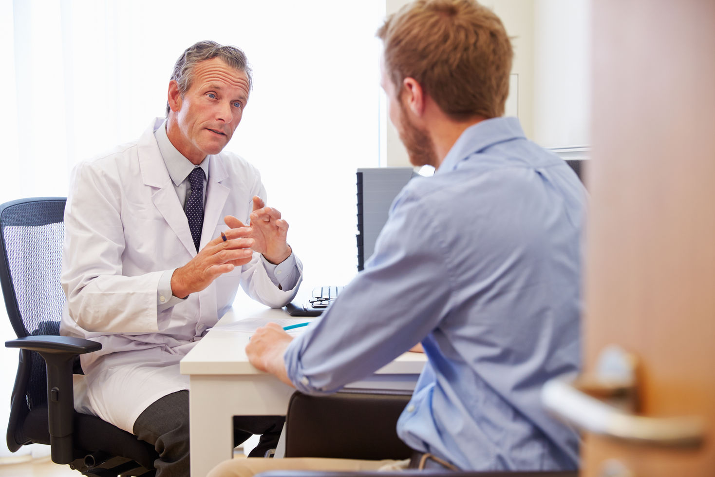 Male Patient Having Consultation With Doctor In Office.jpg