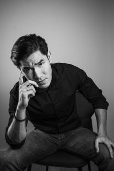 Black and white professional corporate headshot of man in shirt and jeans