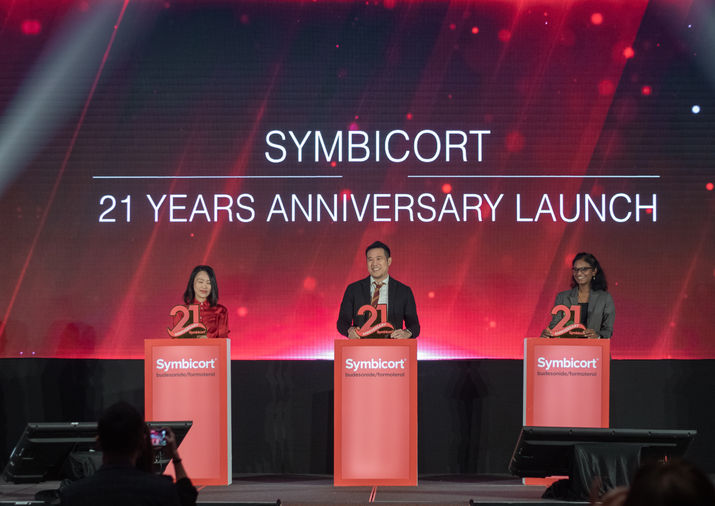 Three professionals commemorating a pharmaceutical company's 21 year anniversary launch