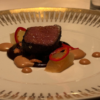 Venison on gorgeous white and gold plate with sauce and appealing set up. Photgraphed by Jabri Fine DIning at Charlie Trotter Pop-up with Next and Dylan Trotter