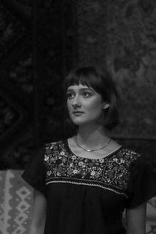 a black and white photo of a woman with short black hair looking to the side, apparently interested in something