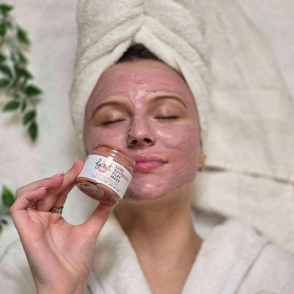 Woman with towel turban and pink face mask holds FaceT skin Luxe Raspberry Clay Mask jar, resting calmly in a spa-like bathroom