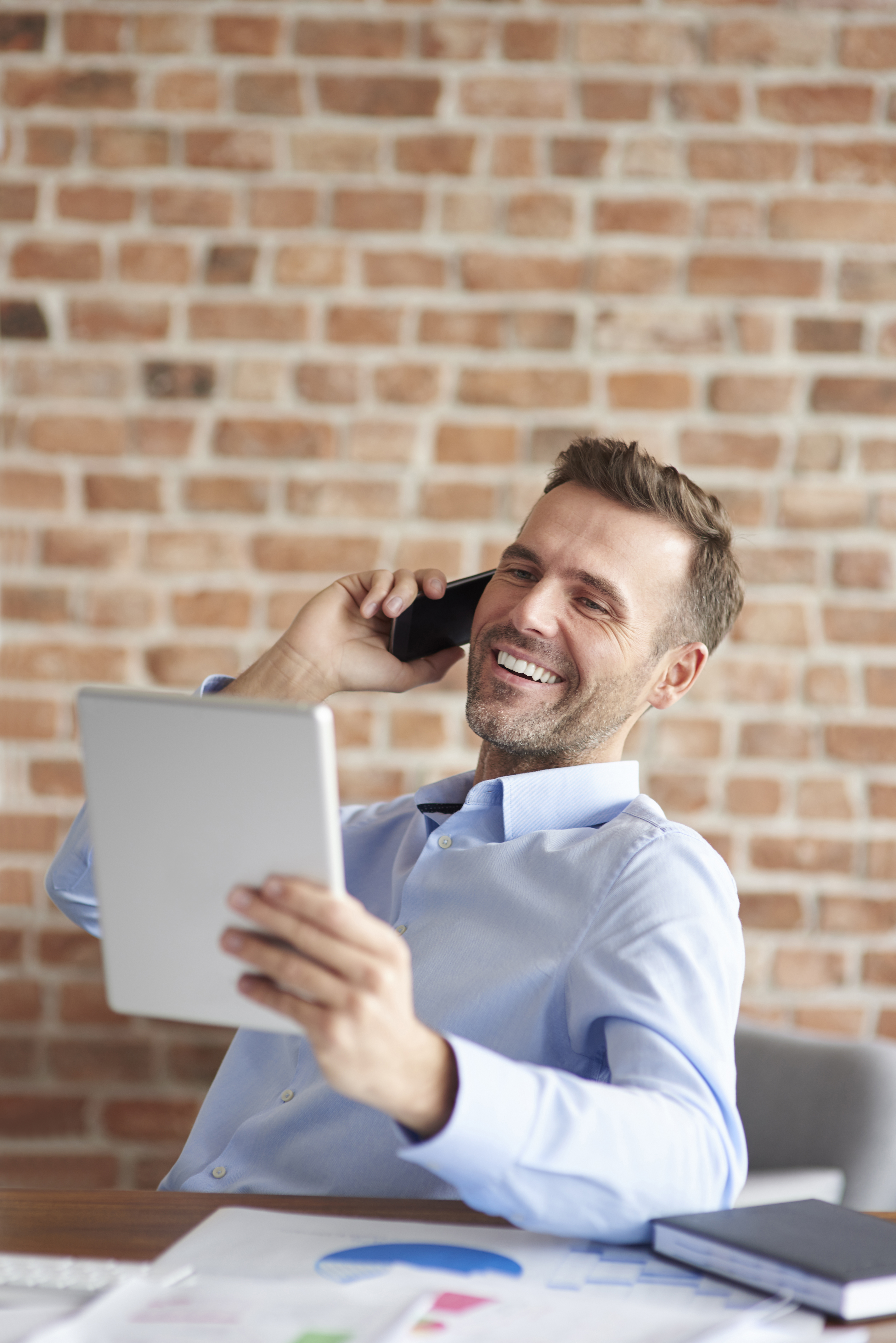man-talking-phone-browsing-digital-tablet.jpg