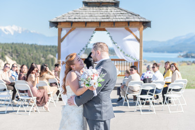 Groom and Bride lovingly looking at each other with the gazebo and guests behind them, Eagle Ranch Resort Wedding