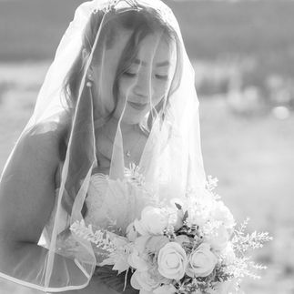 Black and white shot of bride under her veil, looking down on her bouquet. Eagle Ranch Resort Wedding in Invermere