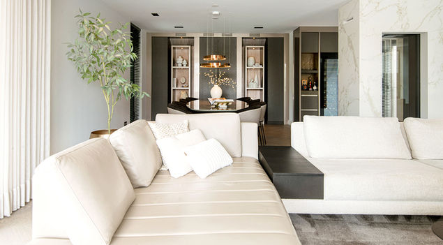 Ruime, moderne woonkamer met beige bank en eettafel