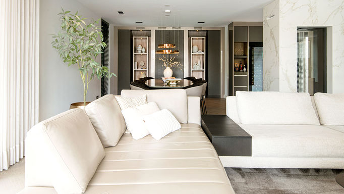 Ruime, moderne woonkamer met beige bank en eettafel