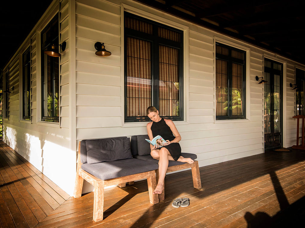 Vrouw leest boek op veranda