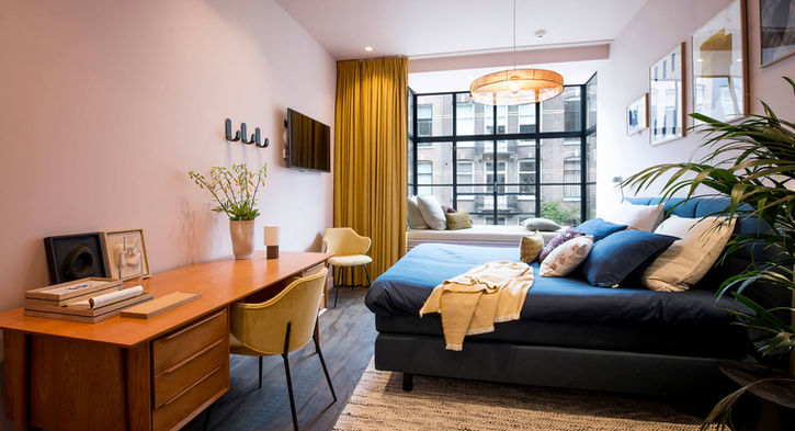 Ruime Airbnb kamer Amsterdam: bureau, bed, raam
