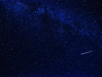 A night sky with a shooting star shining through it.