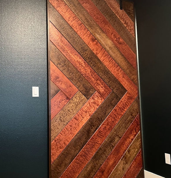 A custom barn door with herringbone design. Alternating chocolate and mahogany finish on quilted pacific maple.