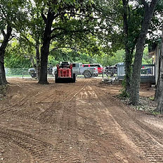 Cleared dirt path leading to construction equipment