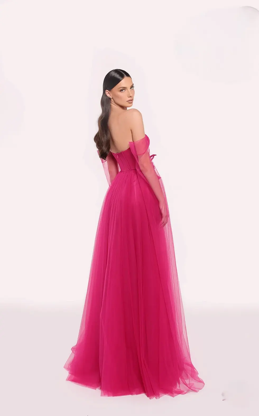 Make a bold statement in this fuchsia pink strapless gown featuring a structured corset bodice and a voluminous tulle skirt.